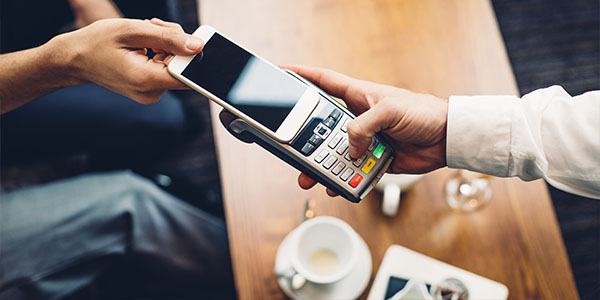 Person using smartphone to pay at shop, using one of a choice of mobile payment apps